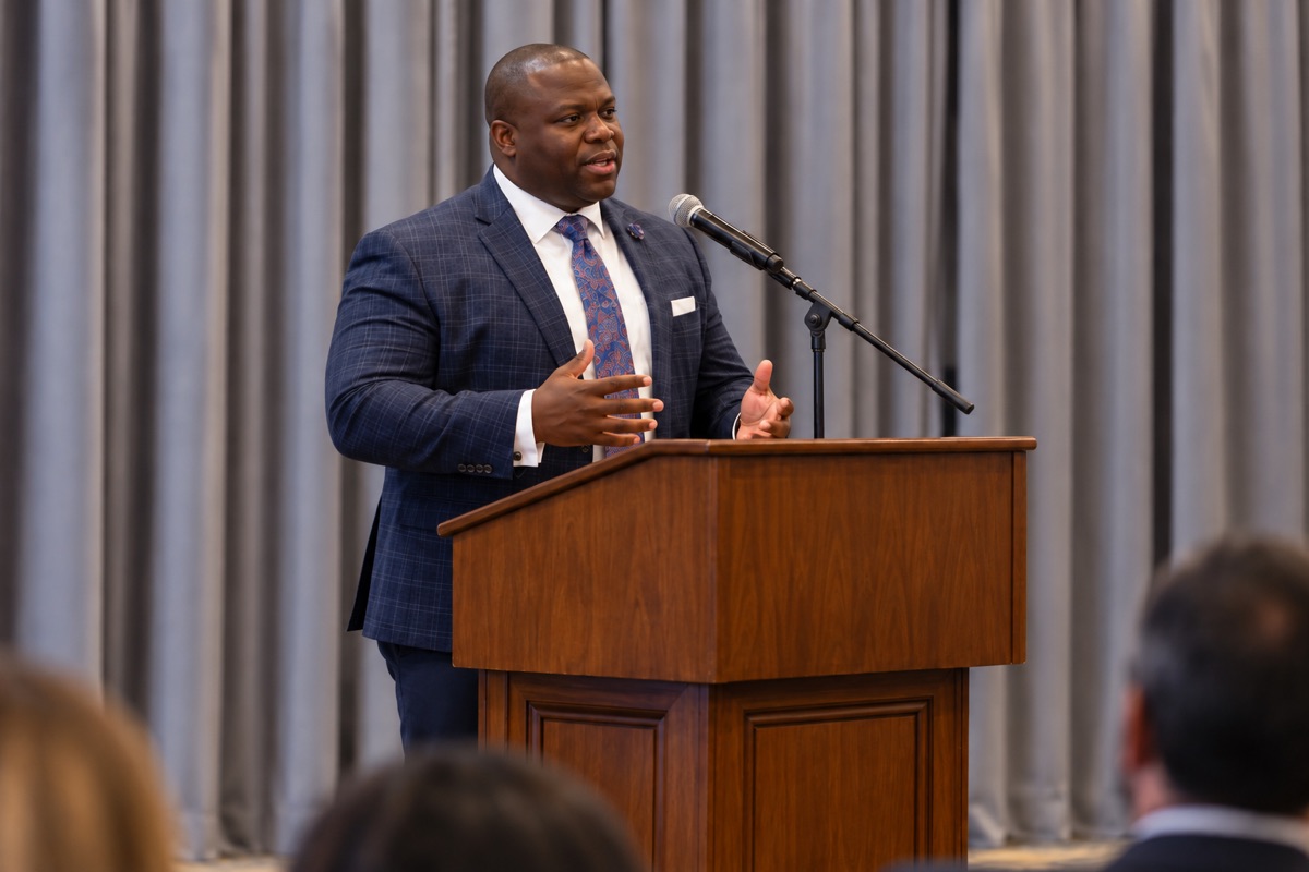 Togar Johnson addressing an audience from a podium